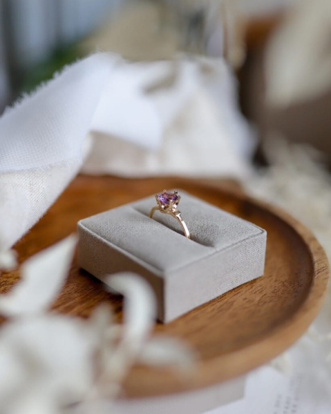 Pierścionek z ametystem szlifowanym diamentowo w oprawie na łapkach, umieszczony w welurowym pudełku, biżuteria ByLucy.